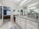 Well-lit bathroom with granite counters, vanity and ample storage; with ensuite access to main bedroom at 33668 Willow Point Ct, Wesley Chapel, FL 33545