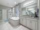 Bathroom with soaking tub, glass-enclosed shower and vanity with granite countertop at 33668 Willow Point Ct, Wesley Chapel, FL 33545