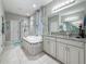 Bathroom featuring tiled floors, soaking tub, glass shower and granite vanity at 33668 Willow Point Ct, Wesley Chapel, FL 33545