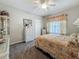 Cozy bedroom featuring floral bedding, a window with curtains, and a curio cabinet, creating a charming atmosphere at 33668 Willow Point Ct, Wesley Chapel, FL 33545