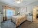 Comfortable bedroom with floral bedding, white wicker furniture, and a ceiling fan for a serene and inviting space at 33668 Willow Point Ct, Wesley Chapel, FL 33545