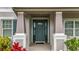 Close-up of a welcoming front door framed by columns and charming planters adding to curb appeal at 33668 Willow Point Ct, Wesley Chapel, FL 33545
