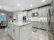 Open kitchen features white cabinets, stainless appliances, granite countertops, and center island at 33668 Willow Point Ct, Wesley Chapel, FL 33545