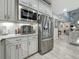 Kitchen featuring stainless steel appliances, white cabinetry, and granite countertops; view to foyer at 33668 Willow Point Ct, Wesley Chapel, FL 33545