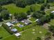 Aerial view of expansive property featuring a pool, RV, multiple barns, and serene countryside surroundings at 3412 Ace Ln, Dover, FL 33527