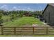 Expansive backyard with lush green grass, wooden fencing, and a charming red barn in the distance at 3412 Ace Ln, Dover, FL 33527