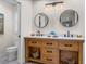 Bathroom featuring a double sink wood vanity and round mirrors at 3412 Ace Ln, Dover, FL 33527