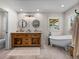 Bathroom with a double sink wood vanity and a claw foot tub at 3412 Ace Ln, Dover, FL 33527