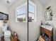 Well-lit bathroom with a toilet, decorative windows, and vanity at 3412 Ace Ln, Dover, FL 33527
