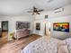 Bright bedroom with wood-look floors, ceiling fan, and paintings at 3412 Ace Ln, Dover, FL 33527