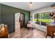 Warm bedroom with wood floors, green accent wall, and large window with a view at 3412 Ace Ln, Dover, FL 33527