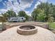 Outdoor fire pit with stone seating, creating a cozy gathering space with an RV parked nearby, perfect for entertaining at 3412 Ace Ln, Dover, FL 33527