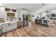 Open concept kitchen with stainless appliances, white cabinetry, breakfast bar, and wood-look floors at 3412 Ace Ln, Dover, FL 33527