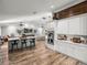 Open concept kitchen with breakfast bar, stainless appliances, white cabinetry, and wood-look floors at 3412 Ace Ln, Dover, FL 33527