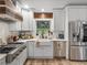 A charming farmhouse kitchen features white cabinetry, a stainless steel range, and a stained-glass window at 3412 Ace Ln, Dover, FL 33527