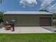 Spacious outbuilding with a large garage door and ample parking, ideal for storage or workshop space at 3412 Ace Ln, Dover, FL 33527