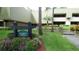 Condominium building exterior with manicured landscaping and signage at Killarney Lodge at 36750 Us 19 N # 09208, Palm Harbor, FL 34684