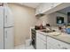 Compact kitchen features white appliances, cabinetry, and tile flooring at 36750 Us 19 N # 09208, Palm Harbor, FL 34684