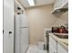 A compact kitchen featuring white appliances, cabinetry, and bright tile floors at 36750 Us 19 N # 09208, Palm Harbor, FL 34684