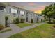 Charming condo complex with lush lawn, sidewalk, and stairs leading to the entrance at 4130 Dolphin Dr, Tampa, FL 33617