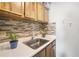 A kitchen featuring a stainless steel sink, tile backsplash, and wooden cabinets at 4130 Dolphin Dr, Tampa, FL 33617