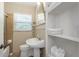 Bathroom featuring a pedestal sink, toilet, shower and shelving for convenient storage, offering a functional design at 4206 W Palmira Ave, Tampa, FL 33629