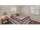 Cozy bedroom featuring a quilt bedspread, wood floors, and two windows, perfect for relaxation and natural light at 4206 W Palmira Ave, Tampa, FL 33629