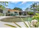 Landscaped backyard featuring a swimming pool, patio, and a screened porch at 4206 W Palmira Ave, Tampa, FL 33629