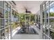 Screened-in porch featuring a ceiling fan, a table and chairs, potted plants, and access to a backyard retreat at 4206 W Palmira Ave, Tampa, FL 33629