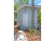 Backyard shed with white door surrounded by greenery and decorative stone adding charm to the outdoor space at 4206 W Palmira Ave, Tampa, FL 33629