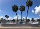 Lovely community pool with palm trees, seating, and a clear blue sky at 4851 W Gandy Blvd # B2L10, Tampa, FL 33611