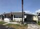 Charming single-story home with a carport, landscaped yard, and an American flag on display at 4851 W Gandy Blvd # B2L10, Tampa, FL 33611
