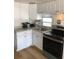 Compact kitchen with white cabinetry, stainless steel appliances, and a bright window at 4851 W Gandy Blvd # B2L10, Tampa, FL 33611