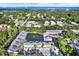 Aerial view showing condo community, pond with water feature, mature trees, and nearby bay at 500 New York Ave # 22, Dunedin, FL 34698