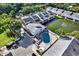 Aerial view of condo community featuring a pool, pond with fountain, and well-maintained landscaping at 500 New York Ave # 22, Dunedin, FL 34698