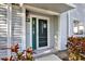 Close-up of the inviting front door, enhanced by colorful foliage and attractive siding at 500 New York Ave # 22, Dunedin, FL 34698