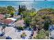 Stunning aerial view of a house with lush greenery, pond, beach, and boats on sparkling blue water at 5240 31St S Ave, Gulfport, FL 33707