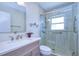 Modern bathroom with glass-enclosed shower, light fixtures, vanity, and accessibility features at 5240 31St S Ave, Gulfport, FL 33707