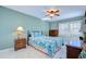 Airy bedroom showcasing light walls, a tropical-themed bedspread, ceiling fan, and natural light at 5240 31St S Ave, Gulfport, FL 33707