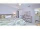 Calm bedroom showcasing light walls, a bed with green tropical bedding, dresser, and ensuite bathroom at 5240 31St S Ave, Gulfport, FL 33707