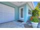 Home entryway showcasing a garage, inviting front door, and well-kept landscaping with vibrant flowers at 5240 31St S Ave, Gulfport, FL 33707