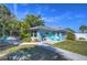 Charming blue home with a manicured front yard, walkway, and inviting outdoor seating area at 5240 31St S Ave, Gulfport, FL 33707