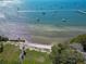 Scenic aerial view of the waterfront, showing a sandy beach, lush greenery, and boats on the clear blue water at 5240 31St S Ave, Gulfport, FL 33707