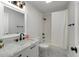Bathroom features white vanity with black hardware, a tub shower with a white shower curtain at 5303 Glen Harwell Rd, Plant City, FL 33566
