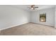 Bedroom with a window overlooking the backyard and neutral colored carpet at 5303 Glen Harwell Rd, Plant City, FL 33566