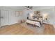 Bright main bedroom featuring wood floors, ceiling fan, closet, bench seat, and neutral-toned decor at 5303 Glen Harwell Rd, Plant City, FL 33566