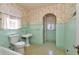 Vintage bathroom with tiled walls, pedestal sink, and arched doorway at 535 22Nd N Ave, St Petersburg, FL 33704