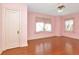 Airy bedroom with hardwood floors, soft pink walls, and two windows at 535 22Nd N Ave, St Petersburg, FL 33704
