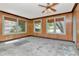 View of the living room with wood paneling, vintage ceiling fan, and windows at 535 22Nd N Ave, St Petersburg, FL 33704