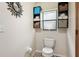 Bathroom features a toilet, storage shelves, and a window, offering a functional and organized space at 5633 99Th N Ter, Pinellas Park, FL 33782